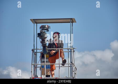 Bayona, Pontevedra, Spanien; 27. August 2024; ein Fernsehkameramann auf einer erhöhten Plattform, der Live-Aufnahmen von einem Sportereignis aufnimmt. Die Nocke Stockfoto