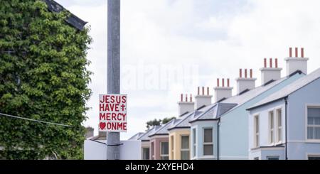 Jesus erbarme mich, christliches evangelisches Schild mit rotem Schriftzug auf dem Pfosten im Stadtzentrum. Ballycastle, Großbritannien - 24. August 2024. Stockfoto