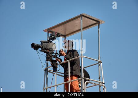 Bayona, Pontevedra, Spanien; 27. August 2024; ein Fernsehkameramann auf einer erhöhten Plattform, der Live-Aufnahmen von einem Sportereignis aufnimmt. Die Nocke Stockfoto