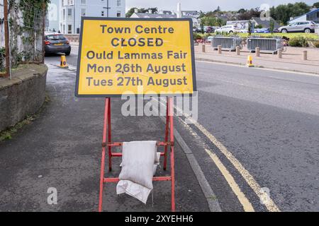 Gelbes Schild mit schwarzem Schriftzug am Straßenrand, auf dem steht, dass das Stadtzentrum wegen Ould Lammas Fair geschlossen ist. Besucherinfo Ballycastle, Großbritannien - 24. August 2024. Stockfoto