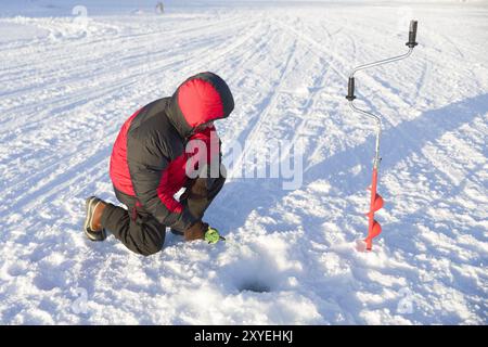 Eisfischen im gefrorenen Fluss Ivalojoki, Ivalo, Finnland, Europa Stockfoto