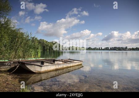 Ruderboot auf einem ruhigen See mit Reflexion Stockfoto