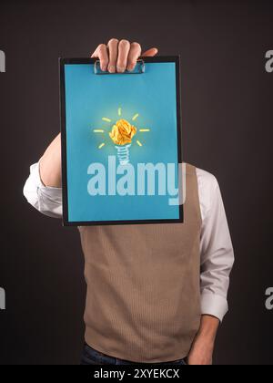 Business-Mann ein Klemmbrett mit einem blauem Papier und eine Glühbirne festhalten Stockfoto