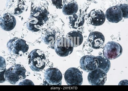 Heidelbeeren in das Wasser sinken mit Luftblasen weißer Hintergrund Stockfoto