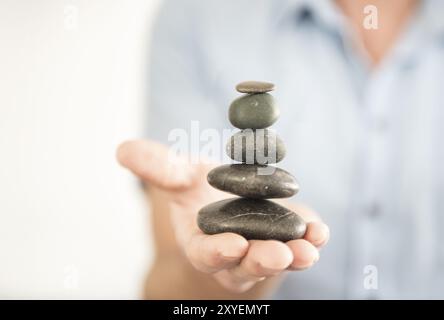 Hand mit Steinturm Stockfoto