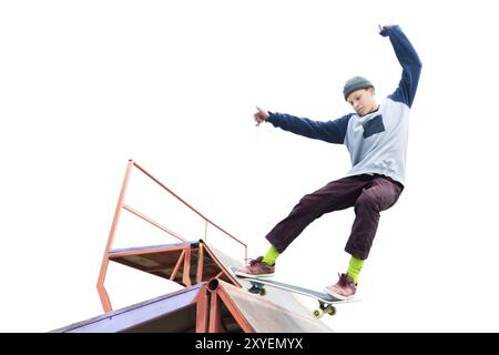 Teenager Skater in Hoodie Sweatshirt und Jeans gleiten über eine Rampe auf einem Skateboard isoliert auf weiß Stockfoto