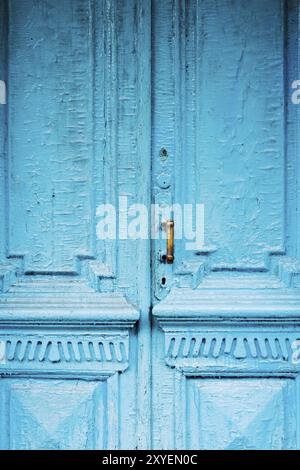 Nahaufnahme von Schlüssellöchern mit Vorhängen und einem Griff auf der blauen, oft gemalten, gerissenen Holztür mit doppeltem Zylinder des letzten Jahrhunderts mit einer Pos. Stockfoto