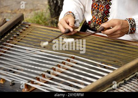 Nahaufnahme der Hände eines hochrangigen Musikers in traditioneller ukrainischer Kleidung, der Hackbrett spielt. Osteuropa Ukraine Kiew Stockfoto