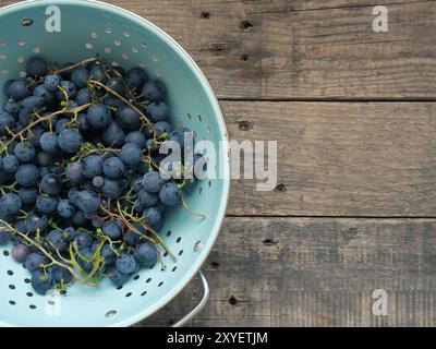 Frische organische Trauben in einem vintage Sieb auf eine rustikale Küche aus Holz Tisch Stockfoto