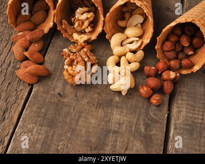 Eis mit organischen Haselnüsse, Mandeln, Cashews und Walnüsse auf einem rustikalen Holztisch Stockfoto
