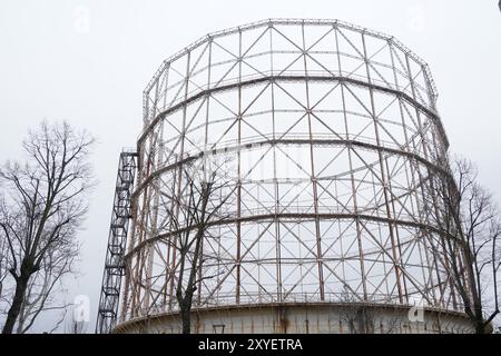 Ein altes Gasometerskelett verlassener Industrieartefakte an einem grauen, regnerischen Wintermorgen. Mailänder Stadtröcke Stockfoto