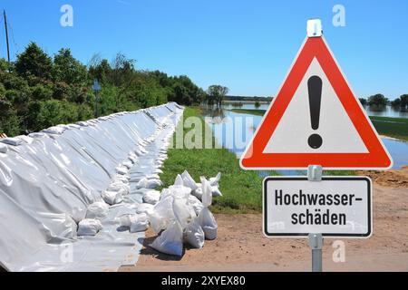 Sandsäcke und Warnschild während des Hochwassers in Magdeburg an der Elbe Stockfoto