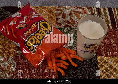 Cheetos knusprig mit einem Glas Milch. Charles Elmer Doolin erfand Cheetos 1948, Frito-Lay ist eine Tochtergesellschaft von PepsiCo. Chester Cheetah-Maskottchen!! Stockfoto