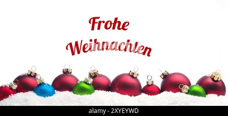 Bunte Weihnachtskugeln in Zeile im Schnee auf einem weißen Hintergrund mit den deutschen Worten Frohe Weihnachten Stockfoto