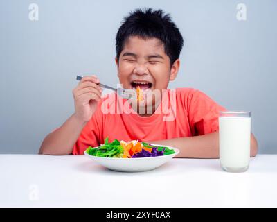 Kinder essen gerne Gemüse, kleiner niedlicher Junge essen gesundes Gemüse, Ernährung gesunde Essgewohnheiten für Kinder Konzept, gemischte Farbe Gemüse. Stockfoto