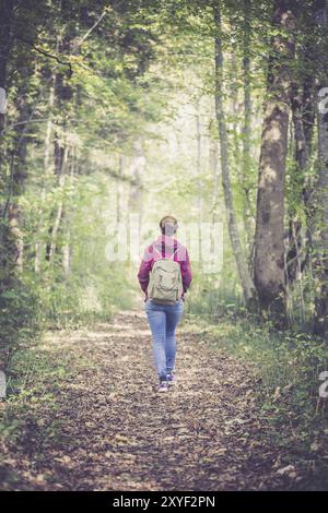 Junge Frau geht im Frühling durch den Wald Stockfoto