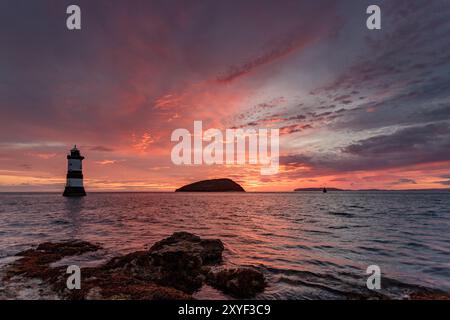 Farbenfroher Morgenhimmel über dem Leuchtturm Trwyn du und Puffin Island am Penmon Point, Anglesey North Wales Stockfoto