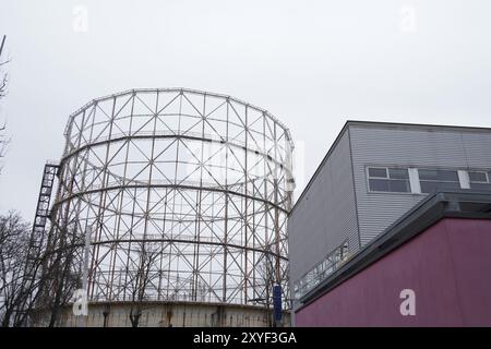 Ein altes Gasometerskelett verlassener Industrieartefakte an einem grauen, regnerischen Wintermorgen. Mailänder Stadtröcke Stockfoto