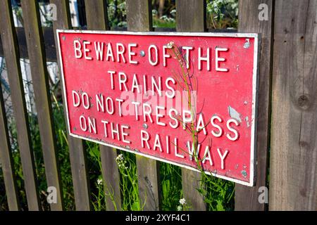 England, Kent, Rolvenden, in der Nähe des Bahnhofs Rolvenden, Warnhinweis „Vorsicht vor den Zügen, die nicht auf die Eisenbahn eindringen“ Stockfoto