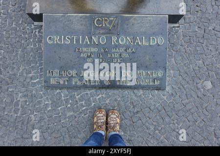 Frau mit ihren Schuhen in der Nähe von CR7 Cristiano Ronaldo statue Plakette in CR7 Stockfoto