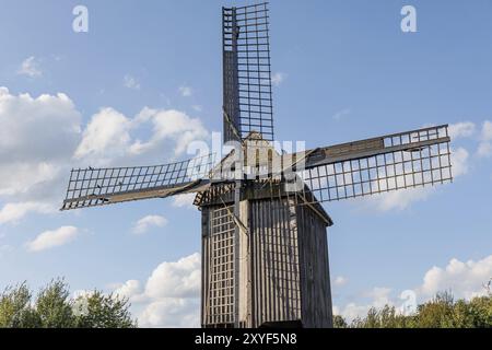 Eine traditionelle Holzwindmühle mit gebrochenen Segeln steht unter einem blauen Himmel mit verstreuten Wolken, weseke, münsterland, deutschland Stockfoto