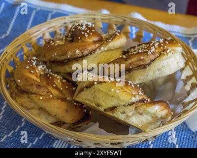 Frische Zimtbrötchen, serviert in einem Korb auf blauer Tischdecke, ystad, schweden, ostsee, skandinavien Stockfoto