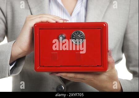 Geschäftsfrau, die roten Safe in den Händen hält. Nahaufnahme Stockfoto