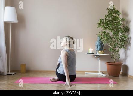 Mittleren Alter oder Reife Frau beim Yoga im Innenbereich Stockfoto