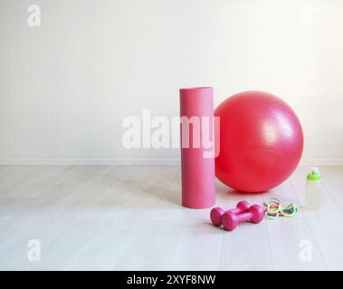 Sportausrüstung. Gym Ball, Yoga Matte, Überspringen Seil, Kurzhantel und Flasche der Wassernaht auf weißem Hintergrund Stockfoto