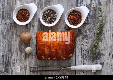 Gefüllter Schweinebauch mit Gewürzen. Gammonfleisch mit verschiedenen Gewürzen auf einem Holztisch Stockfoto