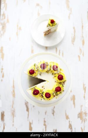 Schöne happy birthday cake mit Mascarpone mit Himbeere, Pistazie und Kerzen auf der Torte stand eingerichtet. Ansicht von oben Stockfoto