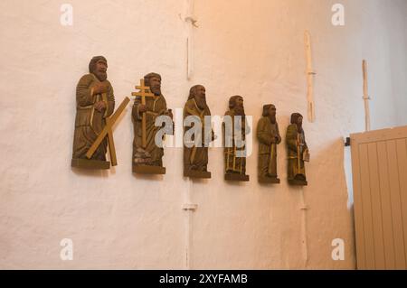 Sechs geschnitzte männliche religiöse Figuren an der Wand der Kirche in Jelling Jütland Dänemark Stockfoto