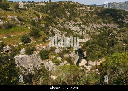 Blick auf den Canyon des Anapo-Tals mit Fluss im Naturschutzgebiet Pantalica, Siracusa, Sizilien, Italien Stockfoto