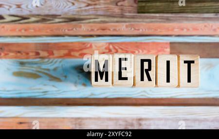 Symbol der Verdienste. Das Konzept des Wortes Verdienst auf Holzwürfeln. Business- und Leistungskonzept. Stockfoto