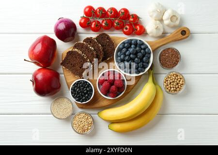 Verschiedene frische Produkte auf weißem Holztisch, flach gelegt. Quelle der Präbiotika Stockfoto