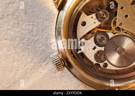 Mechanismus der Vintage-Armbanduhr auf beigem Tisch, Draufsicht. Leerzeichen für Text Stockfoto