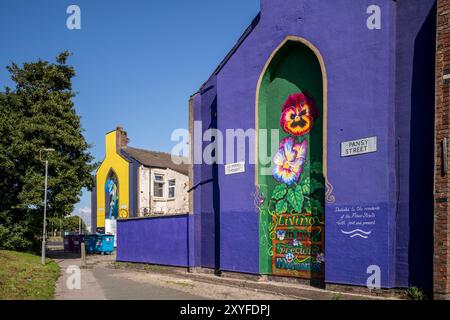 Kirkdale, Liverpool, UK, Flower Street Project 29. August 2024. Das Flower Streets Project ist eine Feier von Kirkdale und seinen Bewohnern und hat bereits neun großformatige Wandmalereien am Giebelende von Häusern hervorgebracht – jedes repräsentiert die gleichnamigen Blumen jeder Straße. Die Kunstwerke sind eine Feier der Gemeinschaft und zielen darauf ab, das Gebiet zu verjüngen und das Thema antisoziales Verhalten zu behandeln. Und jetzt werden zwei weitere unglaubliche Arbeiten in die Kollektion aufgenommen. Die bildende Künstlerin Madeleine Pires, die für alle bisherigen Arbeiten verantwortlich war, kehrte nach Kirkdale zurück Stockfoto