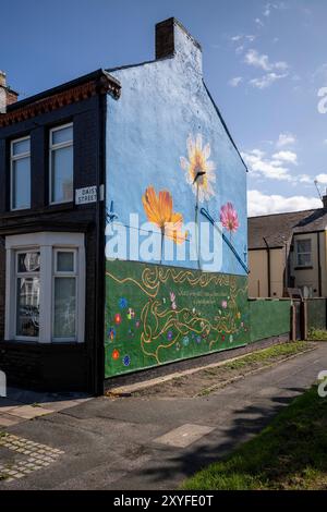 Kirkdale, Liverpool, UK, Flower Street Project 29. August 2024. Das Flower Streets Project ist eine Feier von Kirkdale und seinen Bewohnern und hat bereits neun großformatige Wandmalereien am Giebelende von Häusern hervorgebracht – jedes repräsentiert die gleichnamigen Blumen jeder Straße. Die Kunstwerke sind eine Feier der Gemeinschaft und zielen darauf ab, das Gebiet zu verjüngen und das Thema antisoziales Verhalten zu behandeln. Und jetzt werden zwei weitere unglaubliche Arbeiten in die Kollektion aufgenommen. Die bildende Künstlerin Madeleine Pires, die für alle bisherigen Arbeiten verantwortlich war, kehrte nach Kirkdale zurück Stockfoto