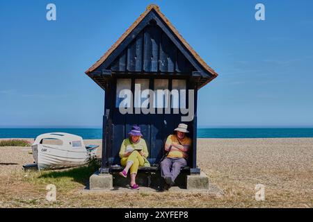 Paare, die sich in einer Fischerhütte am Strand von Aldeburgh an der Ostküste von Suffolk, England, entspannen. Stockfoto