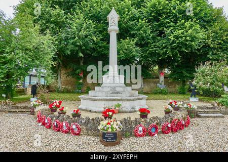 Kriegsdenkmal mit roten Mohnkränzen und Blumen in Bampton, Oxfordshire. Stockfoto