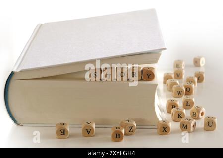Geschichte, Botschaft für kreatives Schreiben, geschrieben mit hölzernen Buchstabenblöcken zwischen den Seiten eines weißen Buches, mehrere verschwommene Buchstabenblöcke herum Stockfoto