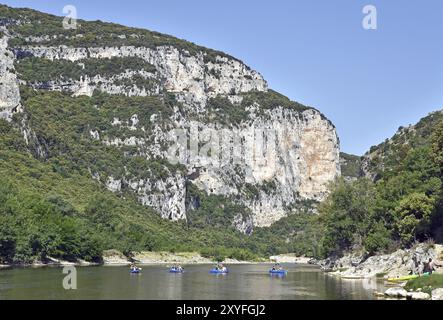 Flusslandschaft mit farbenfrohen Kanus, Wald am Ufer, hohe Klippen Stockfoto