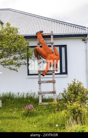 DJUPIVOGUR, ISLAND, 21. JUNI: Dummy in einem orangefarbenen Overall hängt am 21. Juni 2013 in Djupivogur, Island, Europa Stockfoto