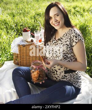 Porträt von schöne schwangere Frau beim Picknick im Frühlingspark Stockfoto