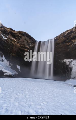 Blick auf den gefrorenen Skogafoss-Wasserfall voller Schnee im Winter in Island Stockfoto