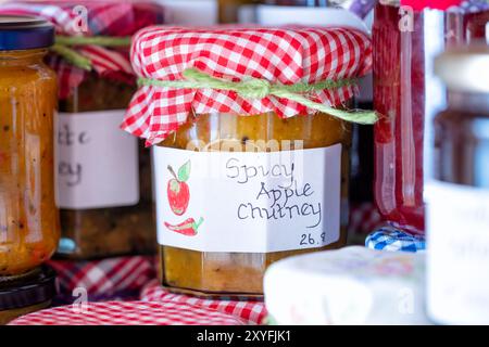 Uk. Hausgemachtes würziges Apfelchutney in Glasgläsern, beschriftet und mit einer Stoffauflage versehen. Hergestellt mit saisonalen hausgemachten Äpfeln Stockfoto