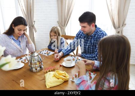 Glückliche junge Familie Plaing Brettspiel mit zwei Töchtern Stockfoto