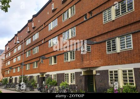 Amsterdam, Niederlande. Juni 2022. Details und Fassaden der charakteristischen Backsteinkonstruktion des Wohngebäudes in Amsterdam Schule Stil architec Stockfoto