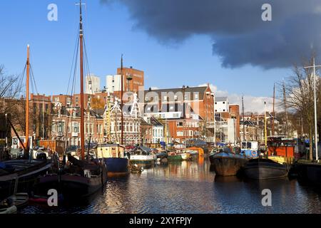 Sonniger Kanal in Groningen mit vielen Flussbooten im Brandsturm Stockfoto