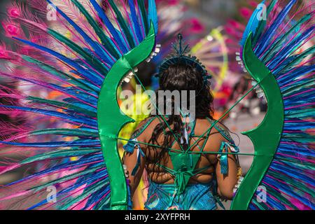 Showtime beim jährlichen Notting Hill Carnival als aufwendig gekleidete Darsteller der Erwachsenenparade schreiten langsam durch West-London Stockfoto